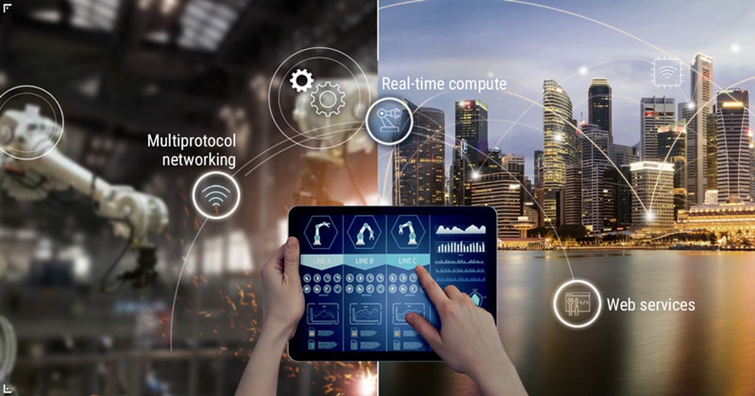 En kompositbild som visar industrirobotar eller maskineri i bakgrunden med ett surfplattegränssnitt i förgrunden som visar kontrolldashboards. Grafik indikerar teknologikoncept som 'Multiprotocol networking', 'Real-time compute' och 'Web services'. Höger sida visar en stadsbild, vilket antyder smarta stads- eller industriella IoT-applikationer.